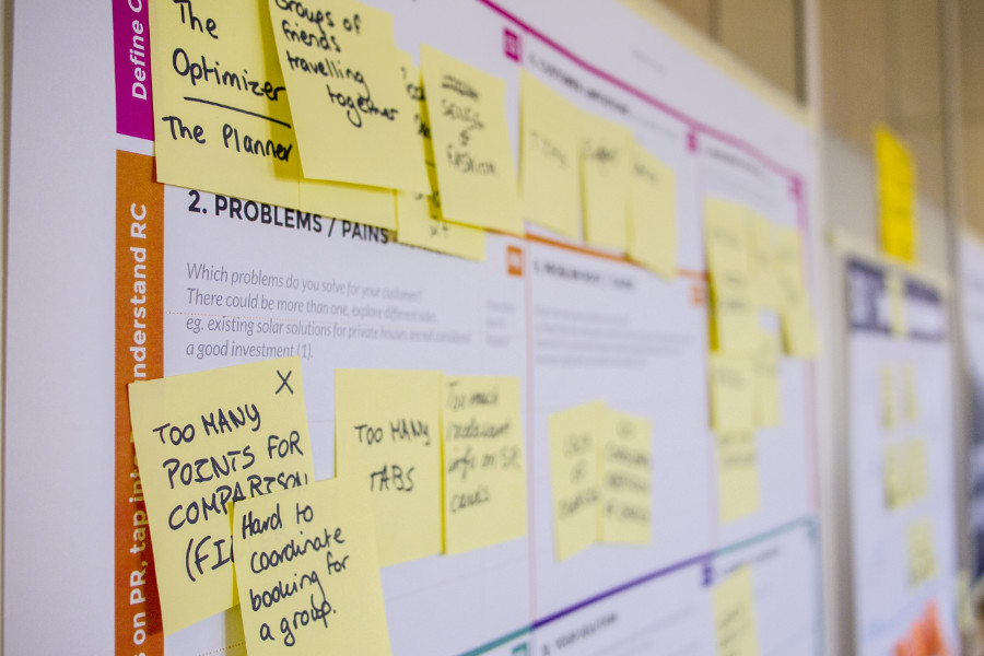 whiteboard displaying user flows and journeys with sticky note comments added