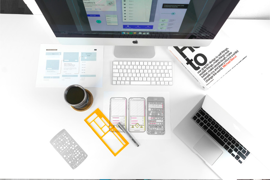 top-down view of a design desk with computer and wireframe work