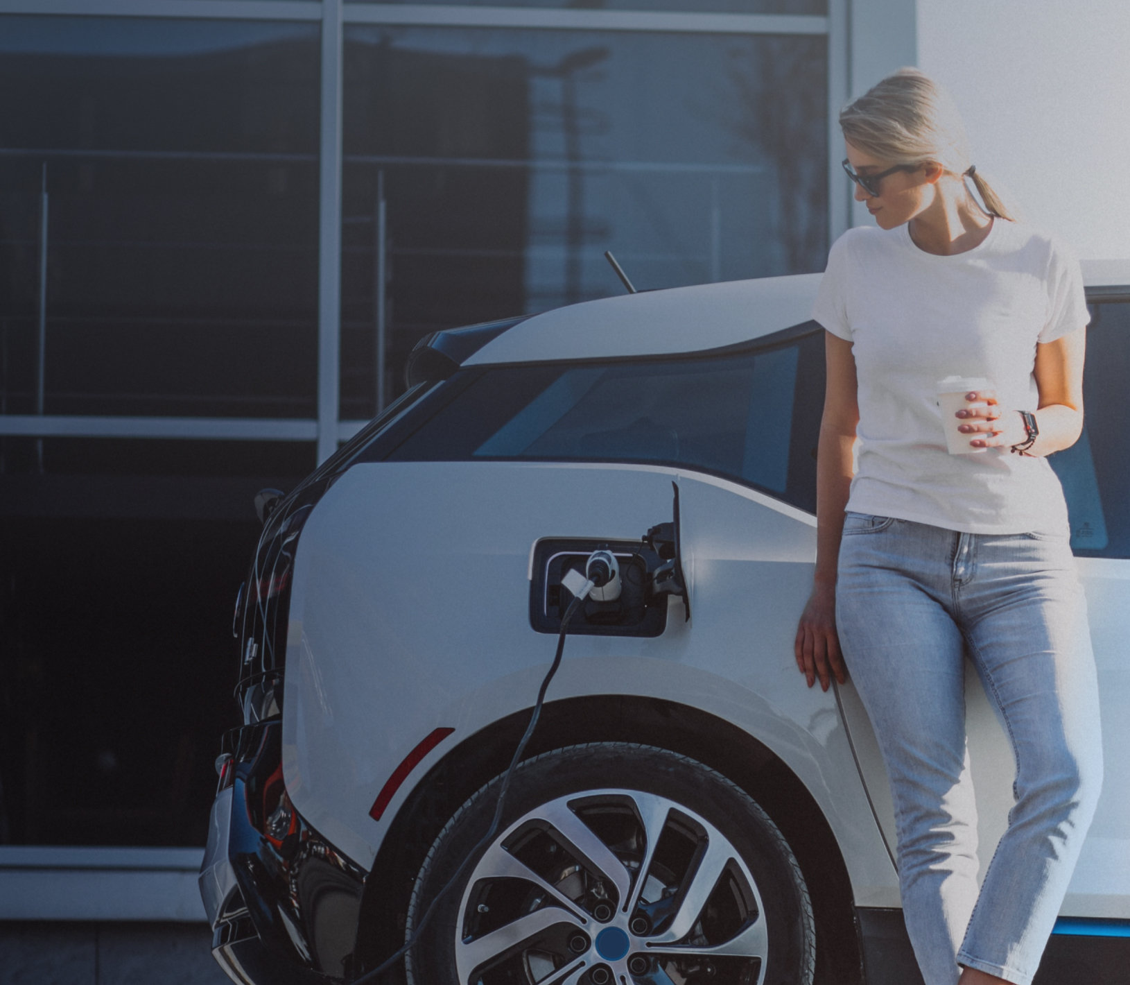 Women standing next to electric car charging