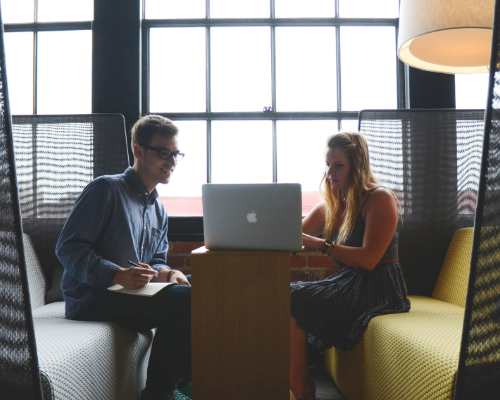 two people looking at a laptop