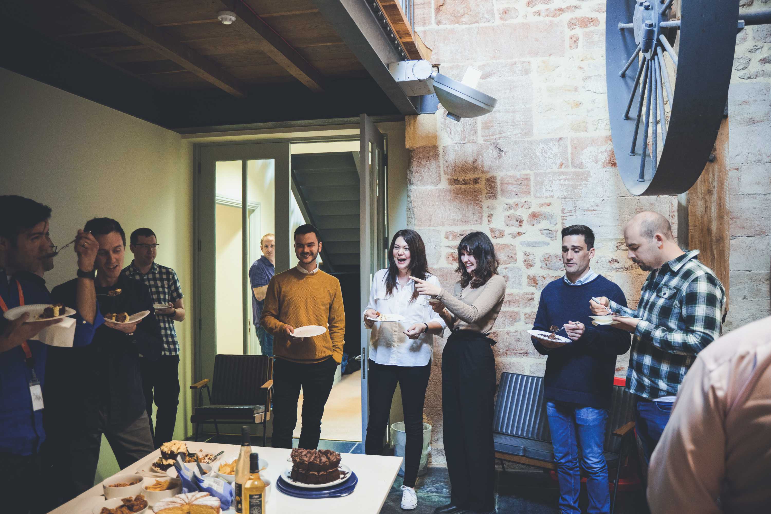 morphsites team members celebrate with cake and party food in the wheel room.