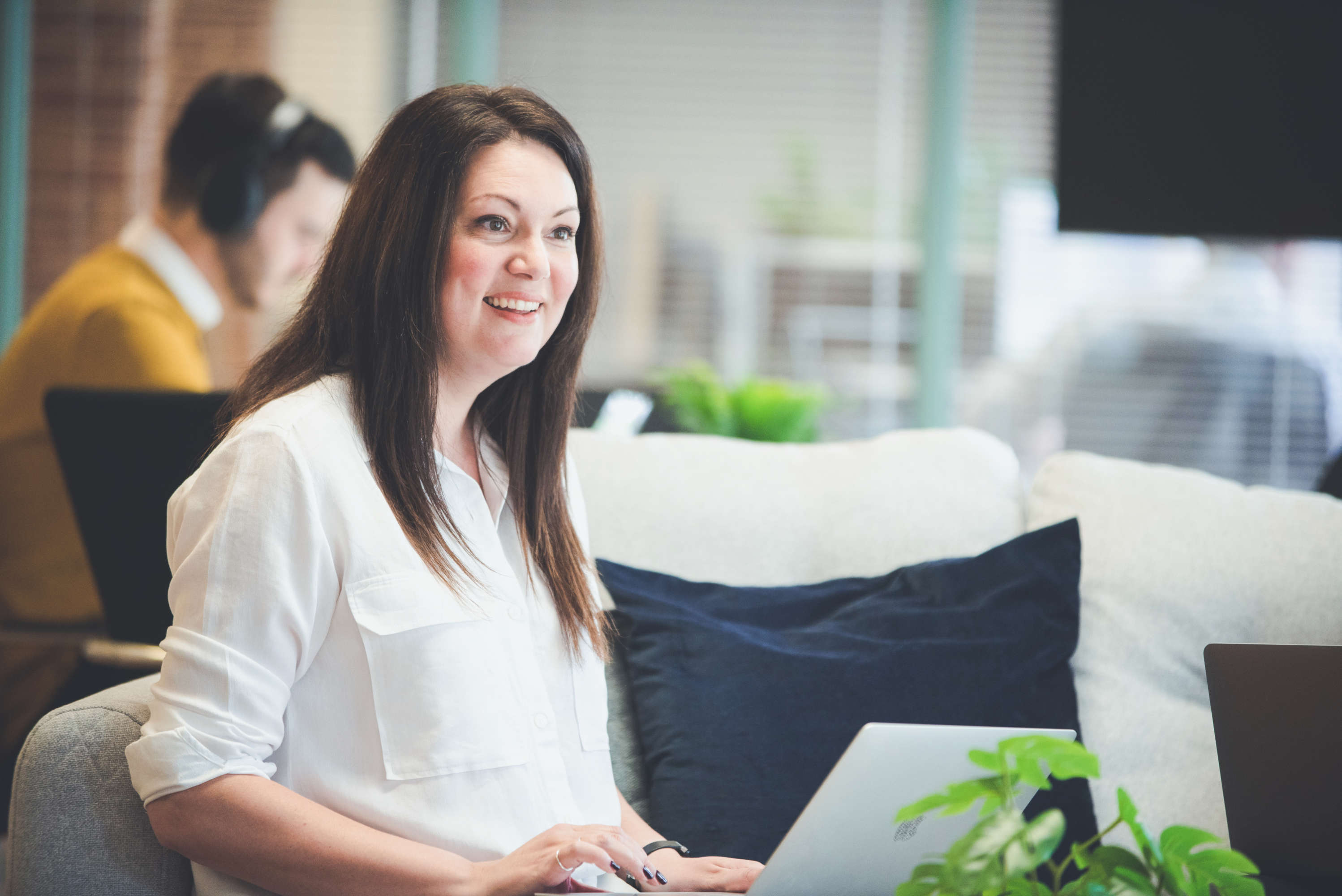 Senior project manager laughs and reacts with surprise to her colleague who is out of frame.