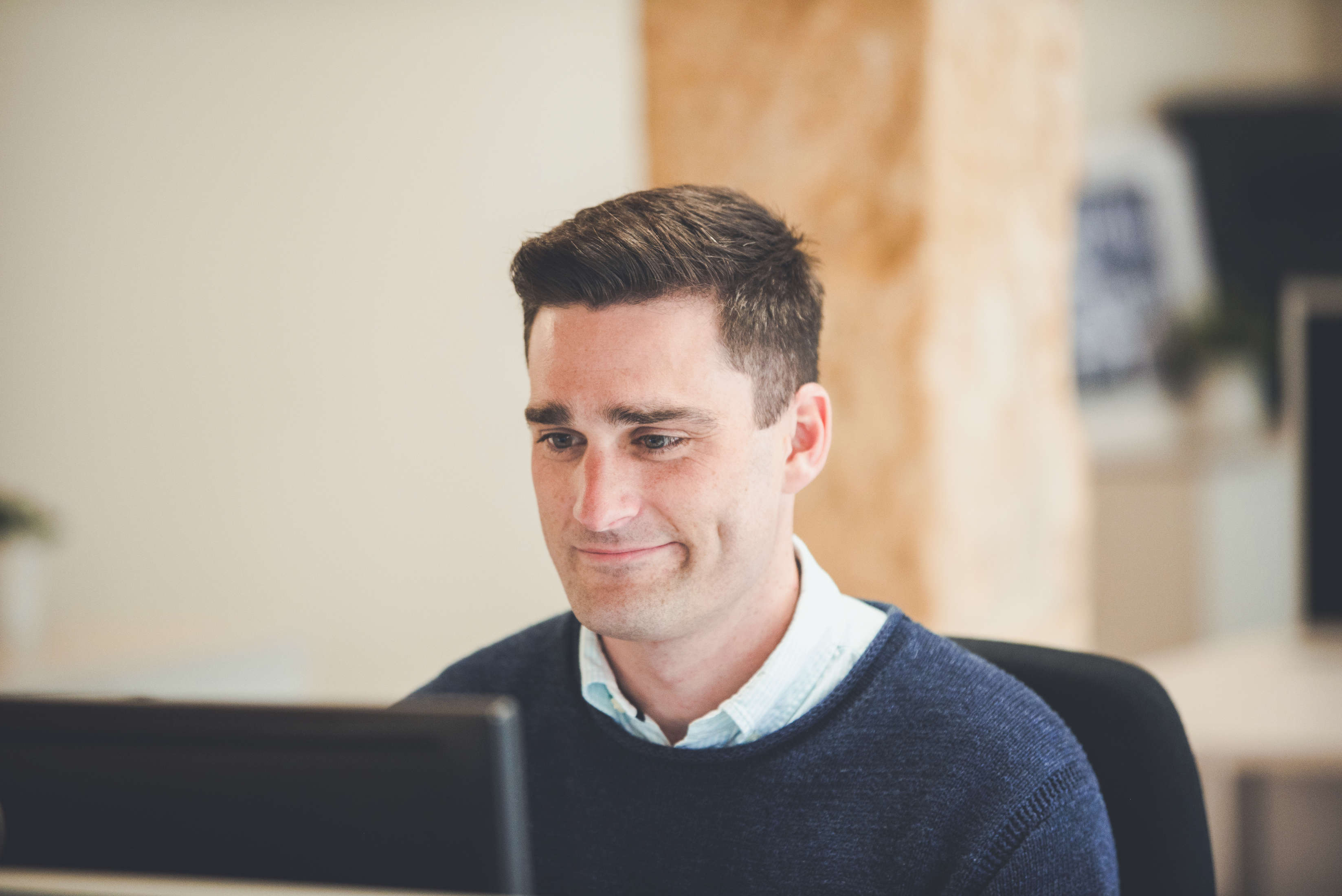 Senior client manager reviews incoming emails on his screen.