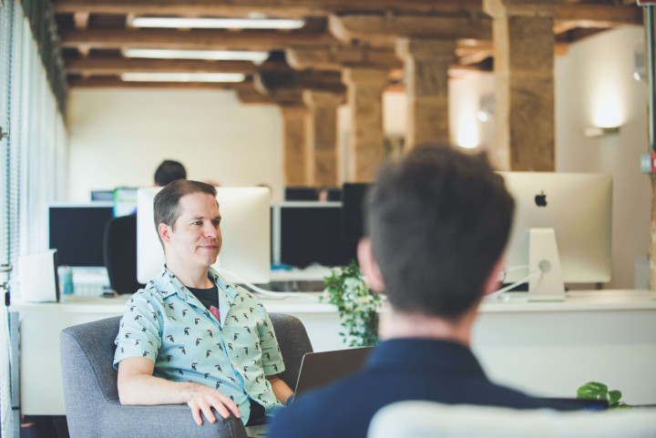Senior designer chats with colleagues during a design meeting.